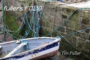 Image ofDinghy tied up to Harbour Wall
